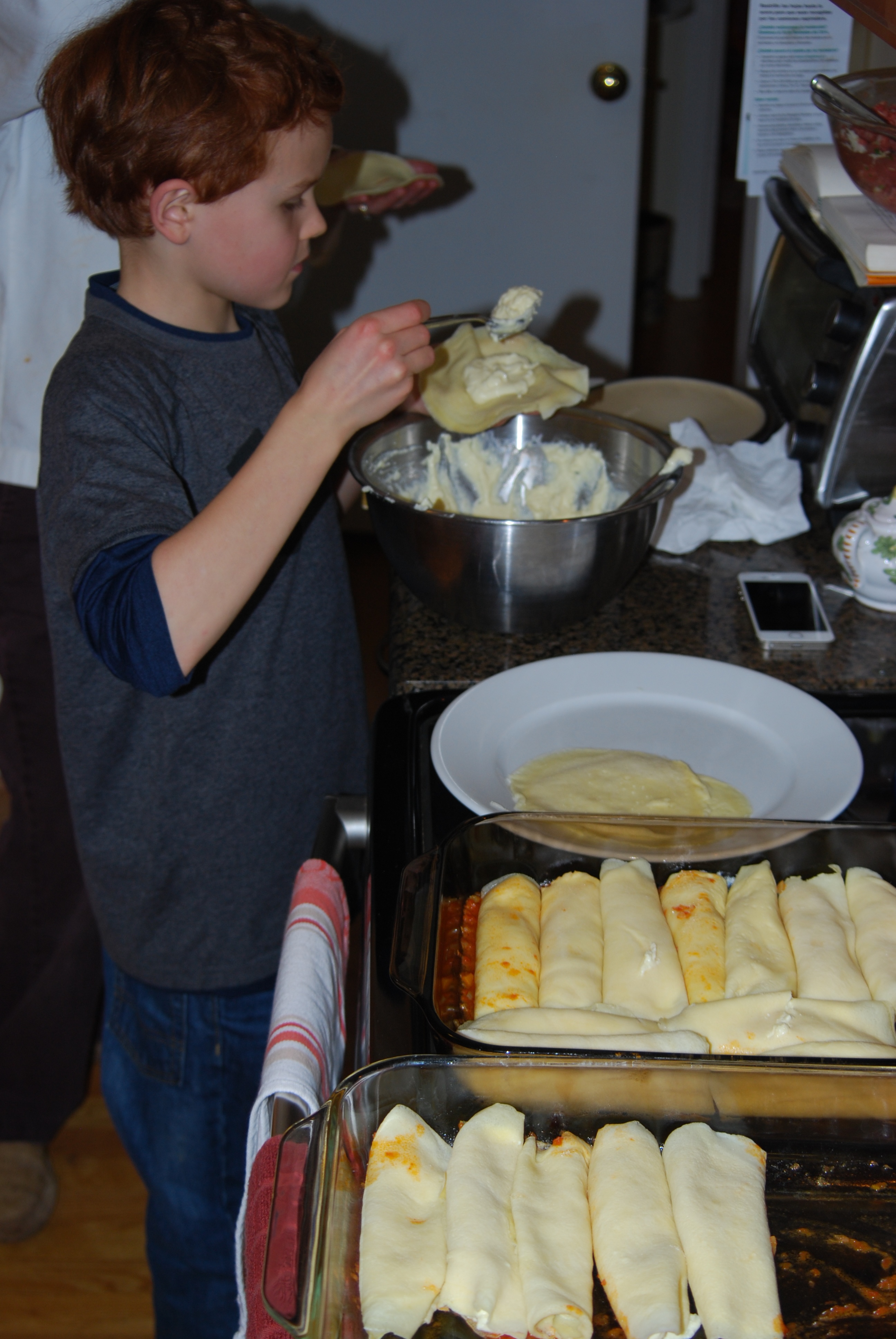 An image of my brother filling Manicotti shells.